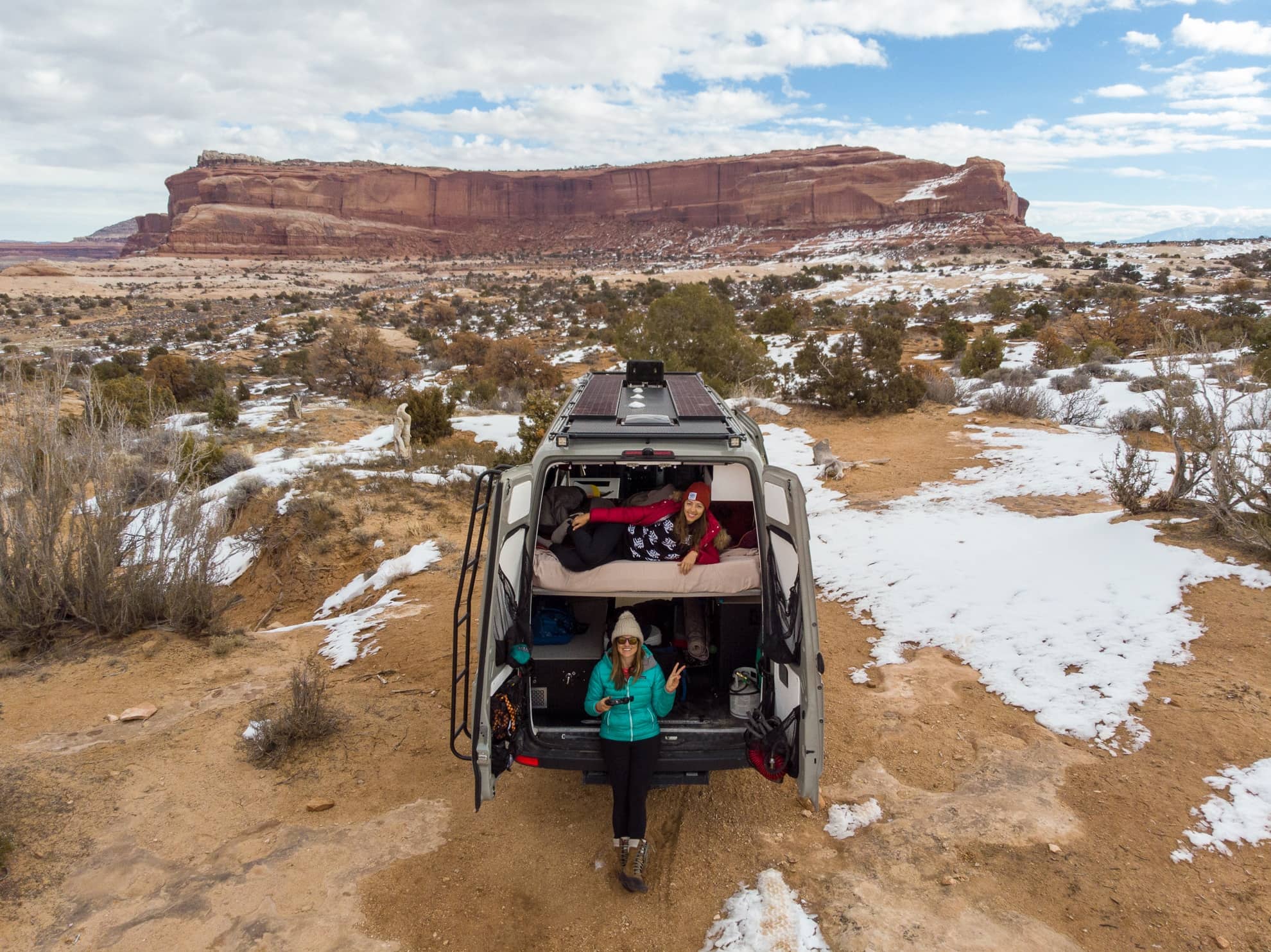 Kristen Bor and another woman sitting in the back of a Sprinter Van in Moab Utah. Shot is taken with a drone